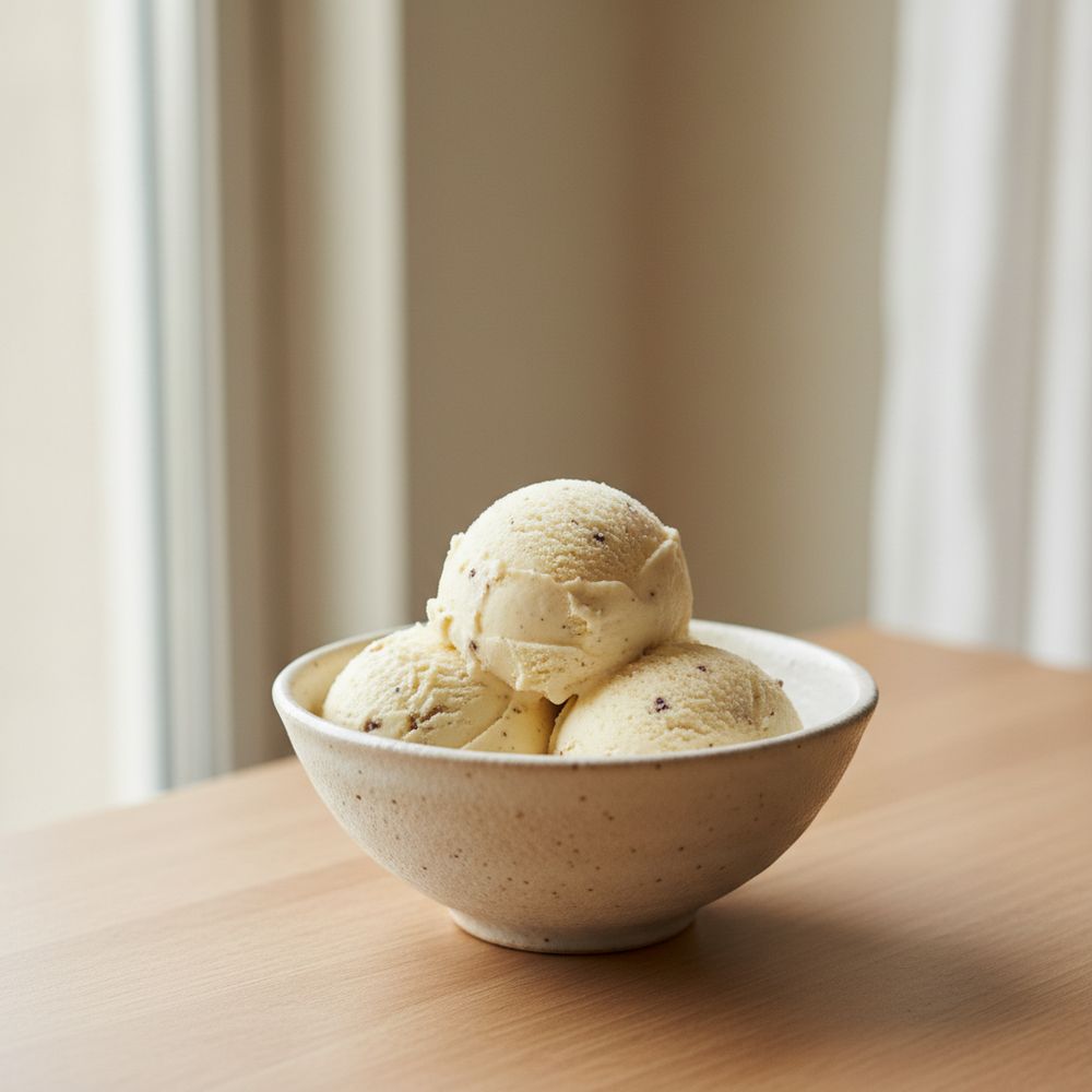 Scoops of creamy vanilla ice cream in a small ceramic bowl